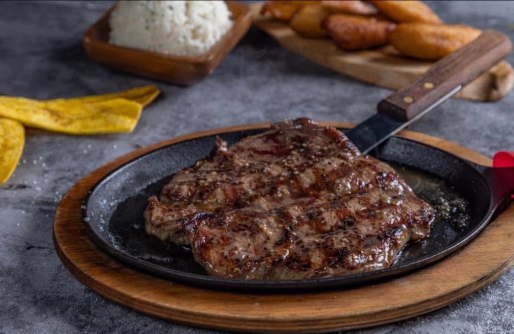 Grilled steak on a sizzling skillet
